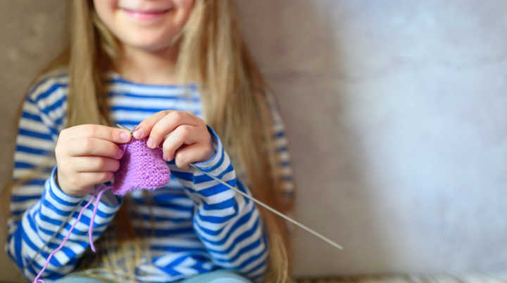 nom-kid-girl-knitting-with-needles-in-home-interior-on-background-of-gray-concrete-wall-the-concept t20 VWmJYl banner