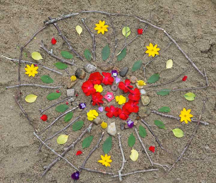 Completed-Beach-Mandala-Made-with-Sticks-Stones-and-Flowers