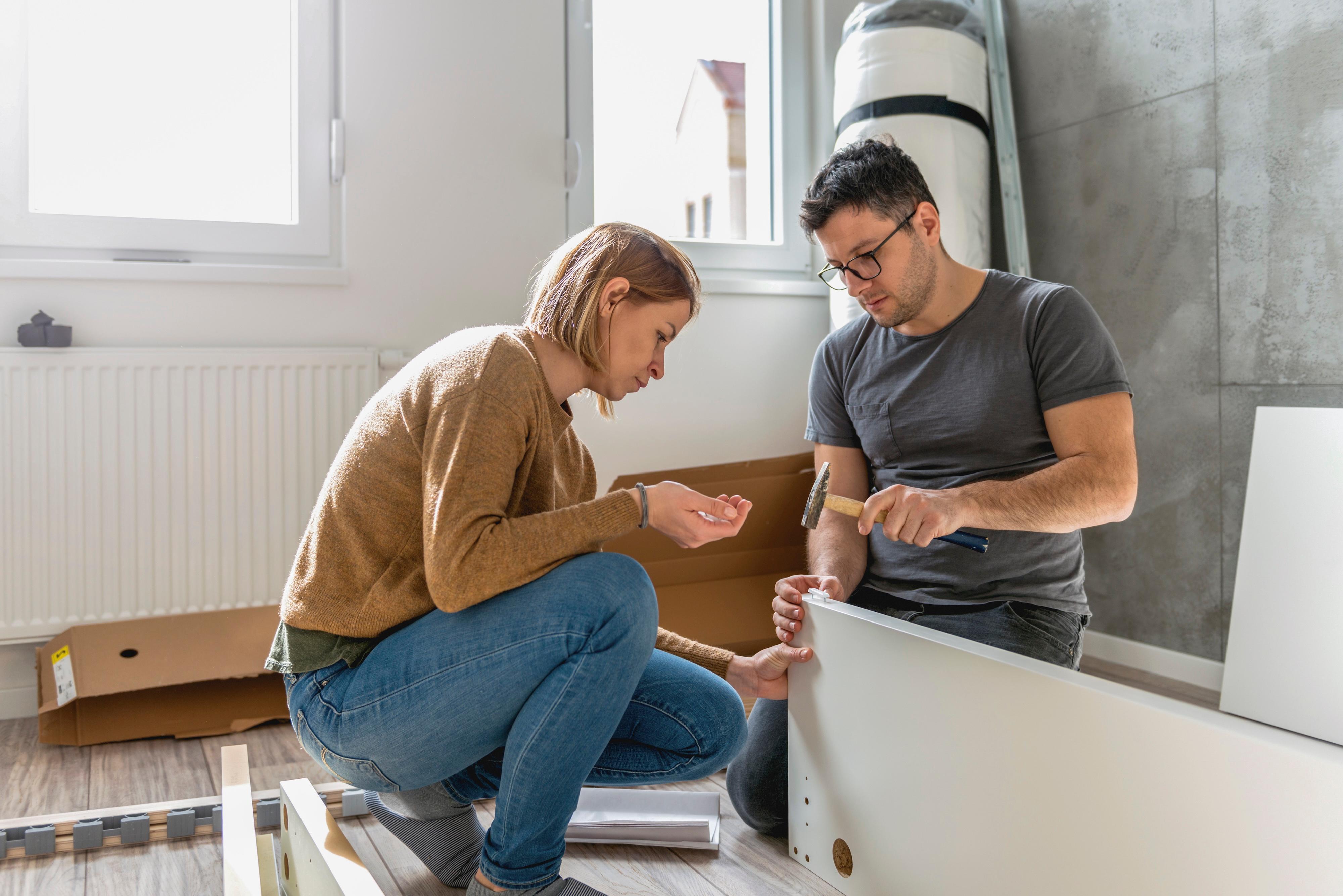 A couple building furniture in their new home