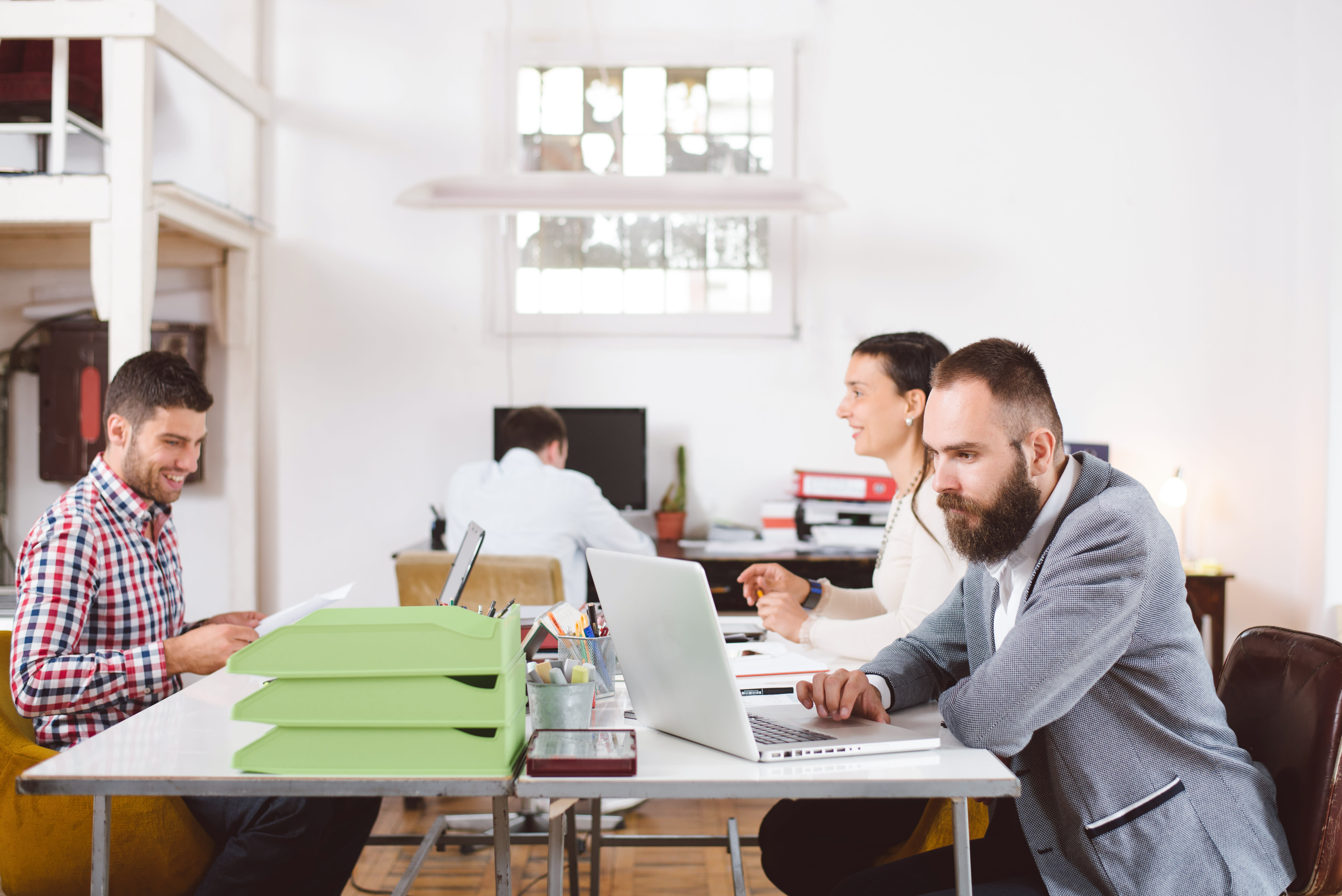 Men working on laptops on table together