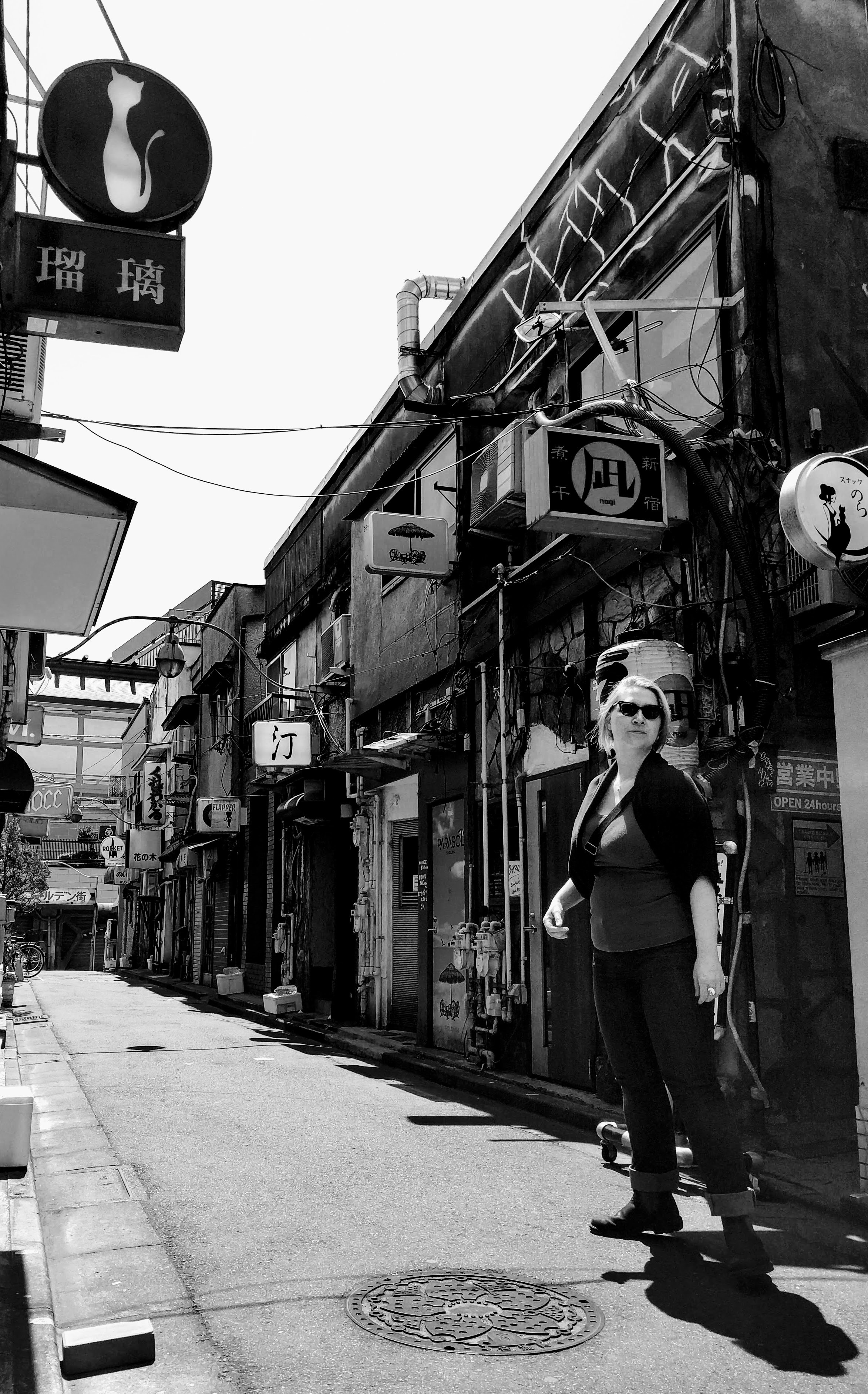 A black and white photo of Nicole Scherbina standing in a market street.