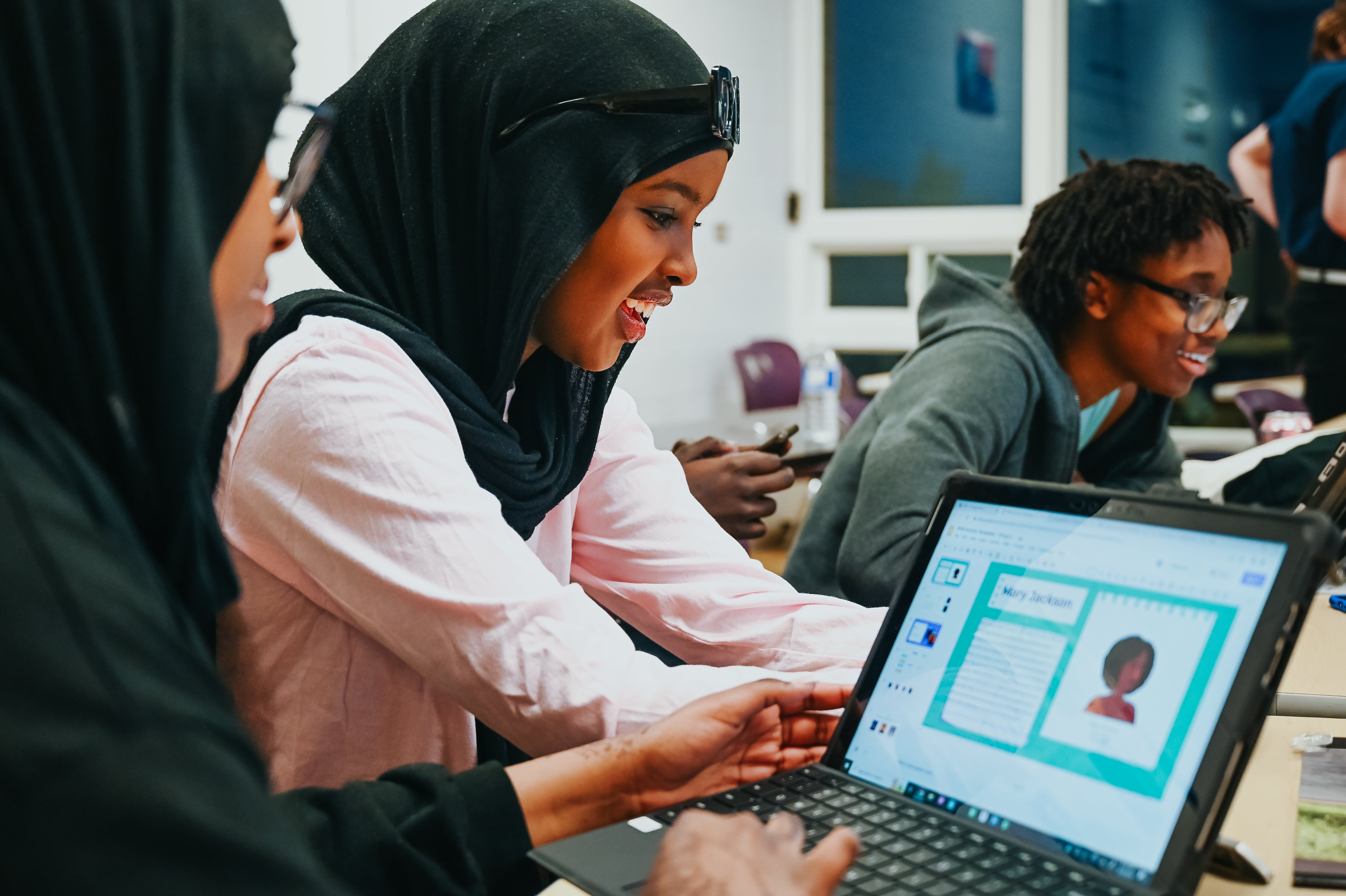 Students working on laptops in a classroom.