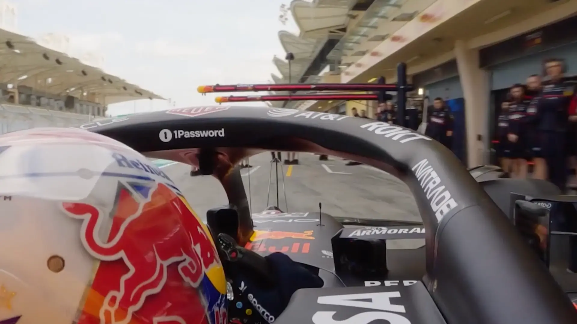 Oracle Red Bull Racing pulls into the paddock, 1Password floats above the driver's eye line as a symbol of security.