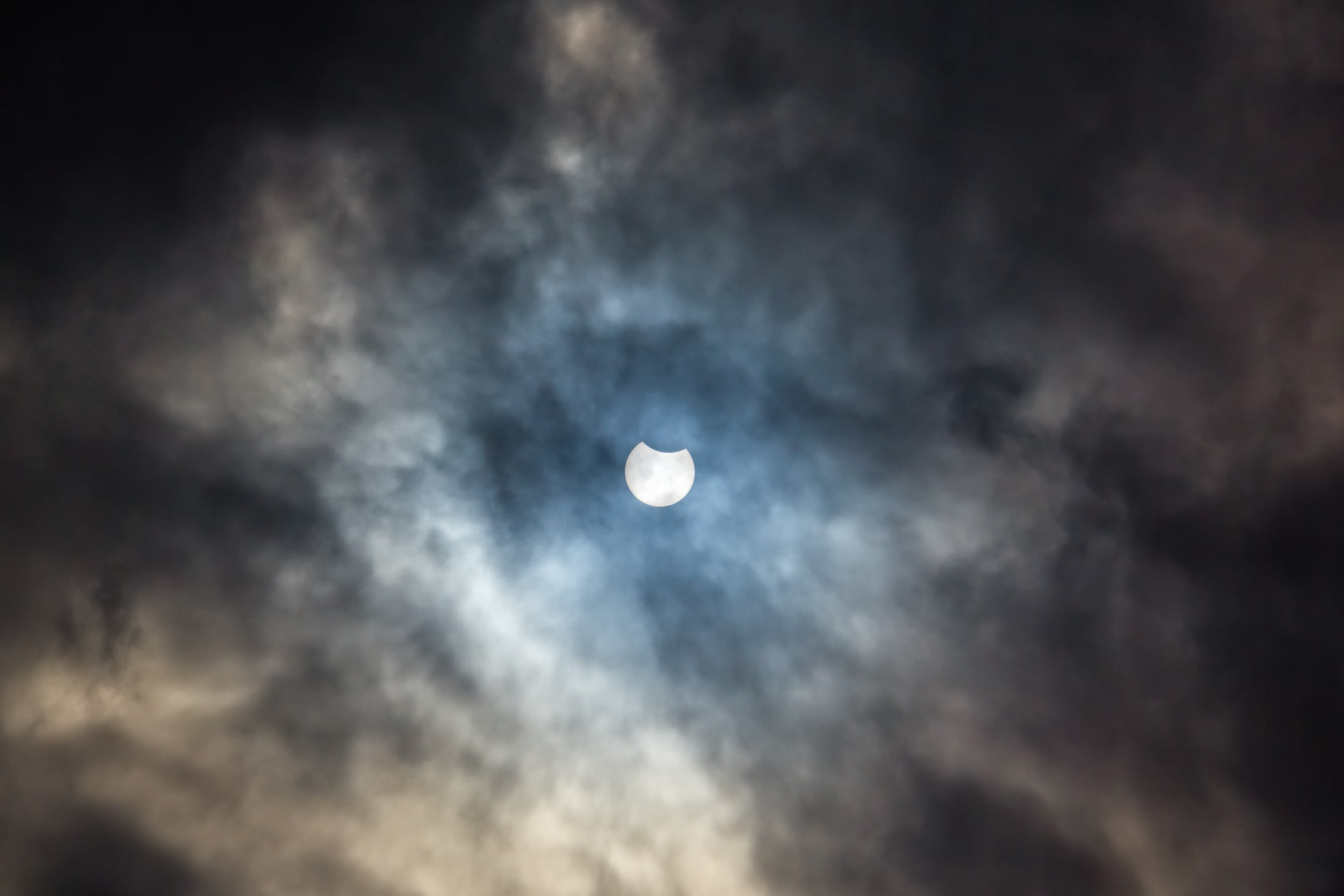 Hapje uit de zon door de maan tijdens gedeeltelijke zonsverduistering. Foto: Adobe Stock / HaiGala