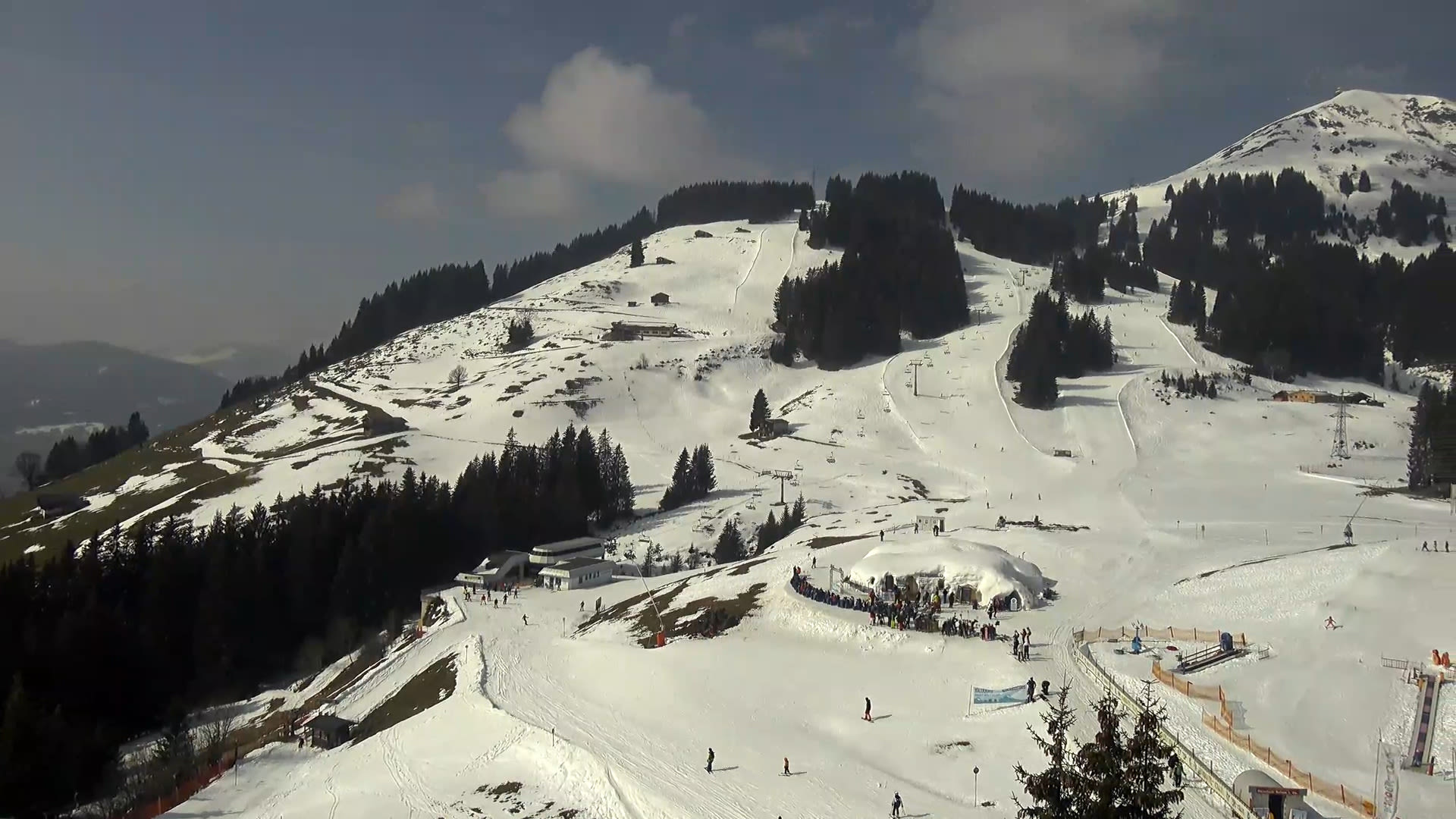 Op de pistes in Brixen im Thale ligt dinsdagochtend nog voldoende sneeuw. Op de hellingen in de zon zijn groene kleuren te zien. Beeld: Feratel