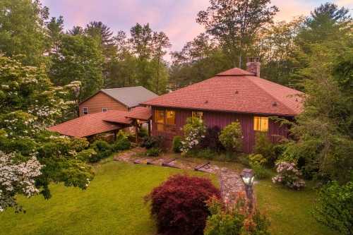 A colorful summer sunset casts a Lake Glenville home and garden in an orange hue.