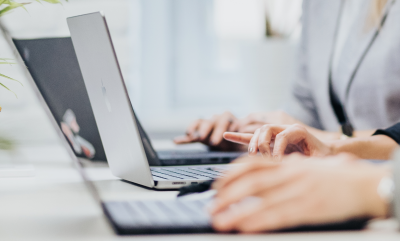 Hands typing on laptop keyboards.