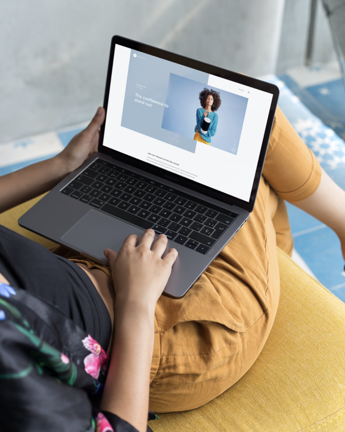 Woman sitting on the couch with a laptop displaying a screen of a woman with a sound speaker.