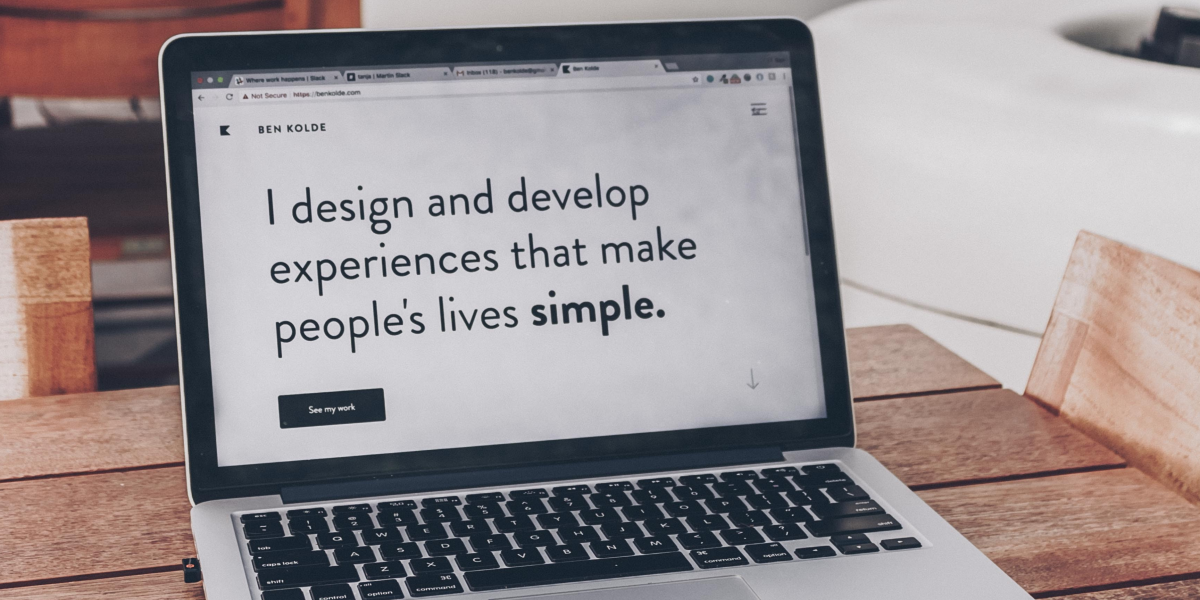 The laptop screen displaying the words: I design and develop experiences that make people's lives simple.
