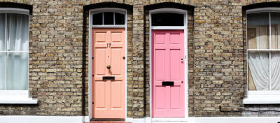 Two colourful entrance doors in a brick wall.