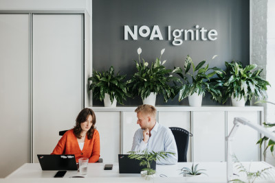 Two people discussing during their work in the NoA Ignite reception.