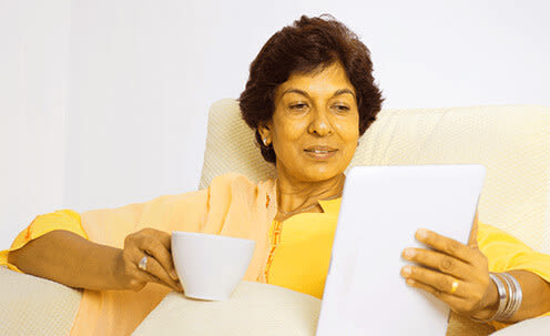 Mulher idosa sentada tomando café