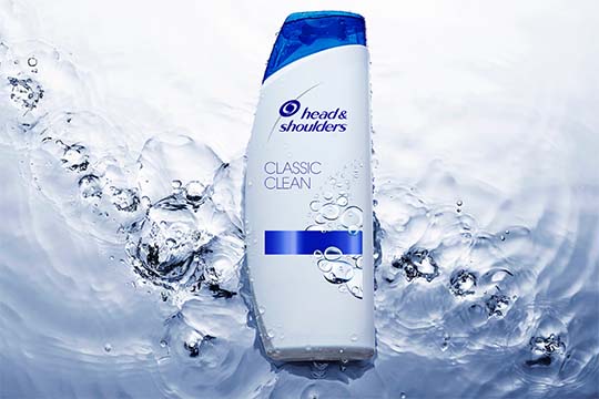 Butelka klasycznego szamponu Head&Shoulders skąpana w krystalicznej wodzie.