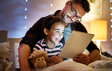 Dad reading a bedtime story to his daughter, so she can get a restful sleep