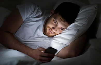 Bedtime procrastination - men looking at his phone 