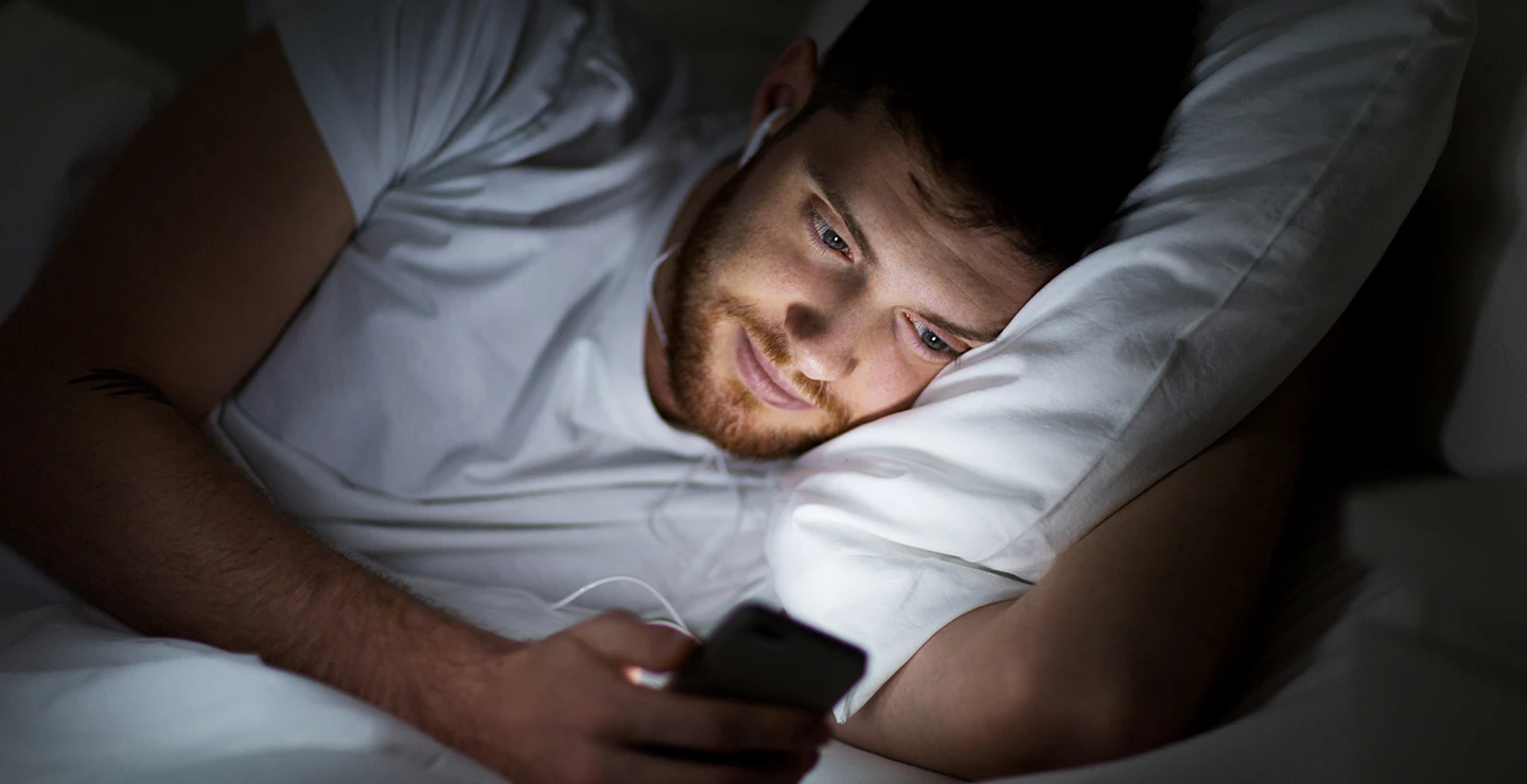 Bedtime procrastination - men looking at his phone 