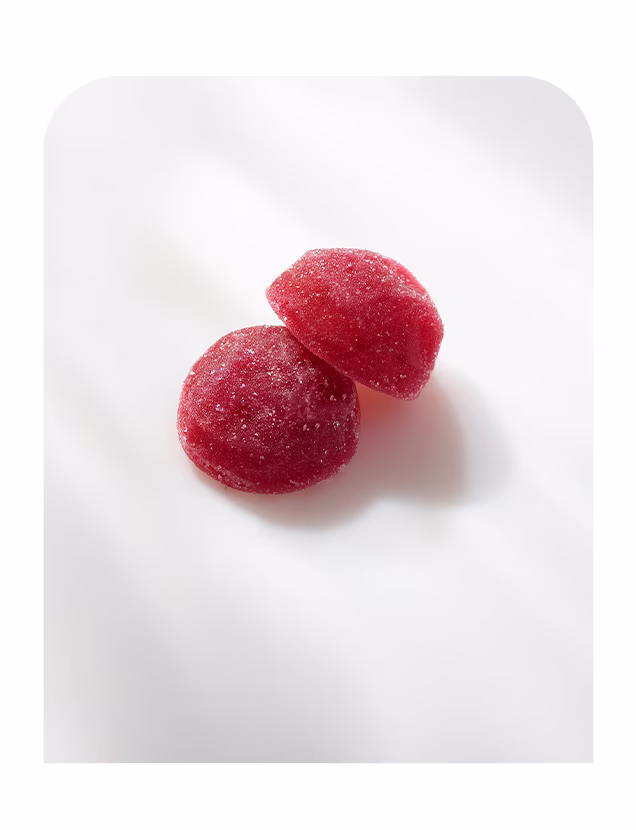 Two red sugar-coated sleep aid gummies on a white background.