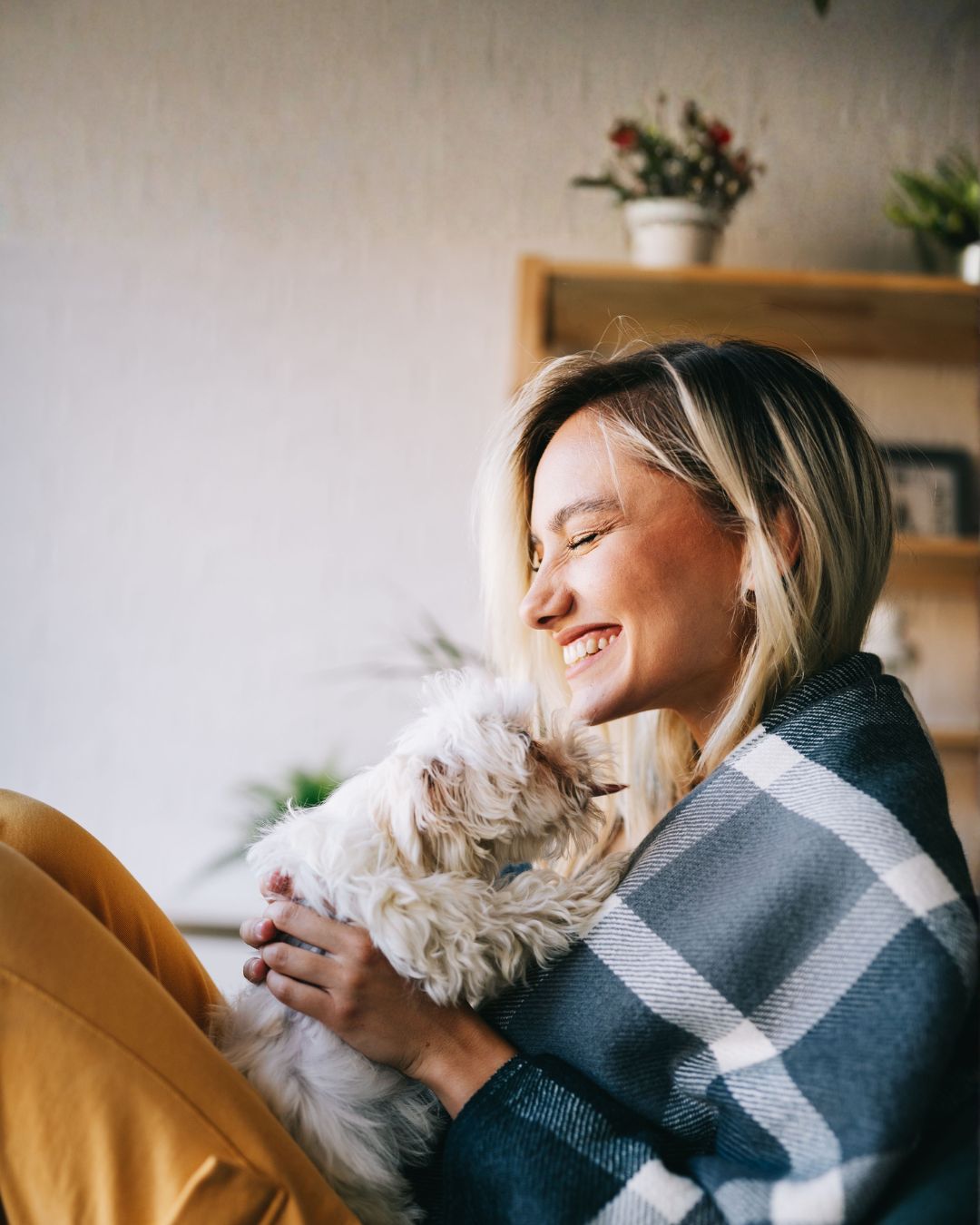 PKS:n iloinen sähkösopimus asiakas pitää koiranpentua sylissään ja hymyilee.