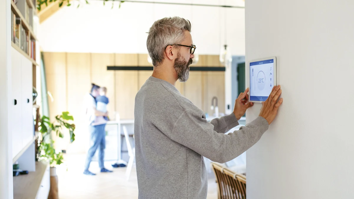 mies säätää kodin lämmitystä loman ajaksi