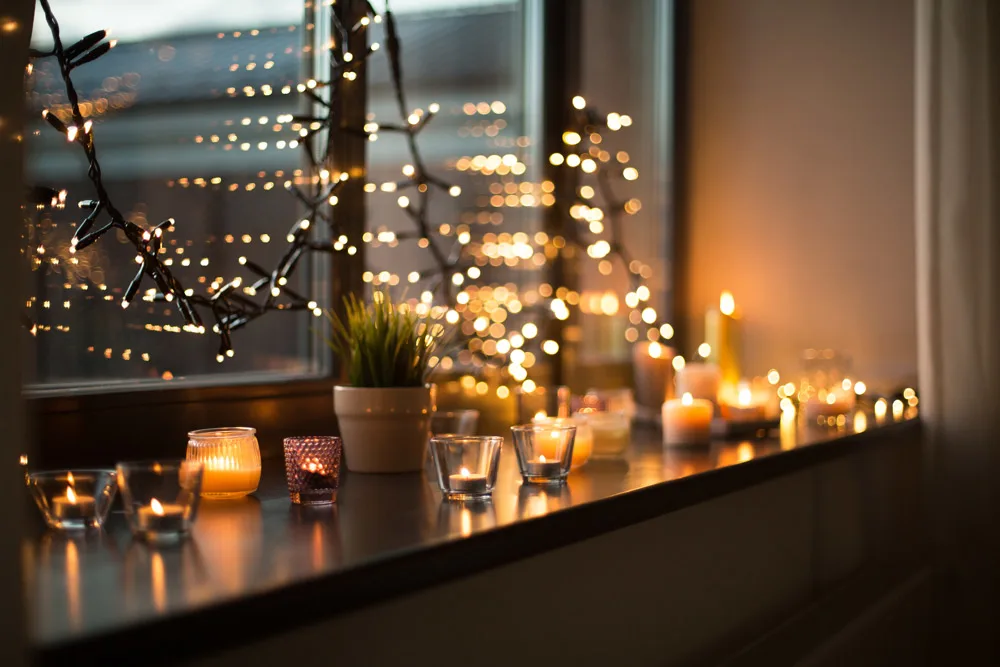 Kynttilät ja jouluvalot ikkunalaudalla