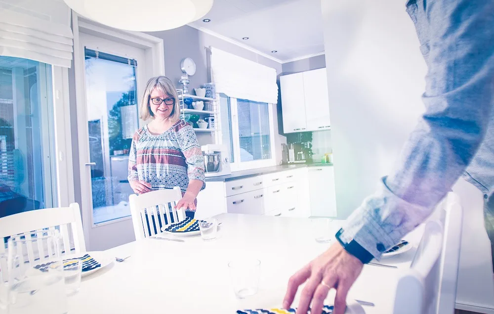 Nainen ja mies kattavat ruokapöytää.