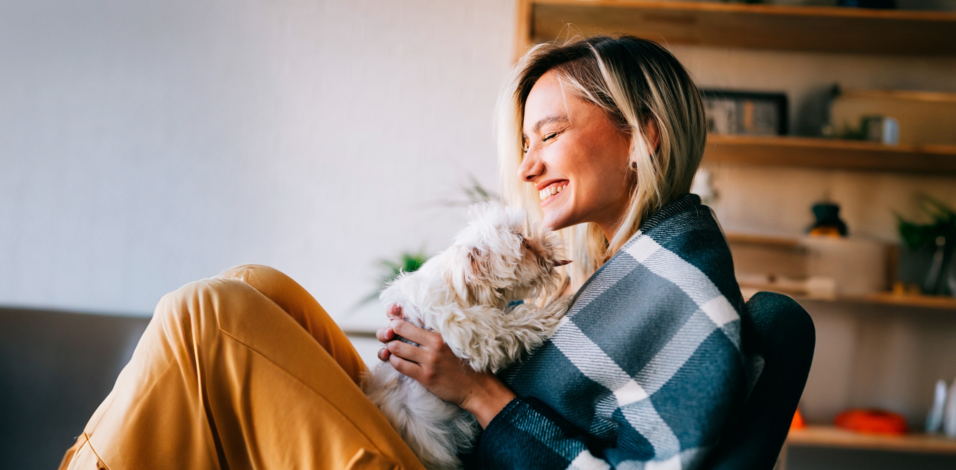 PKS:n iloinen sähkösopimus asiakas pitää koiranpentua sylissään ja hymyilee.