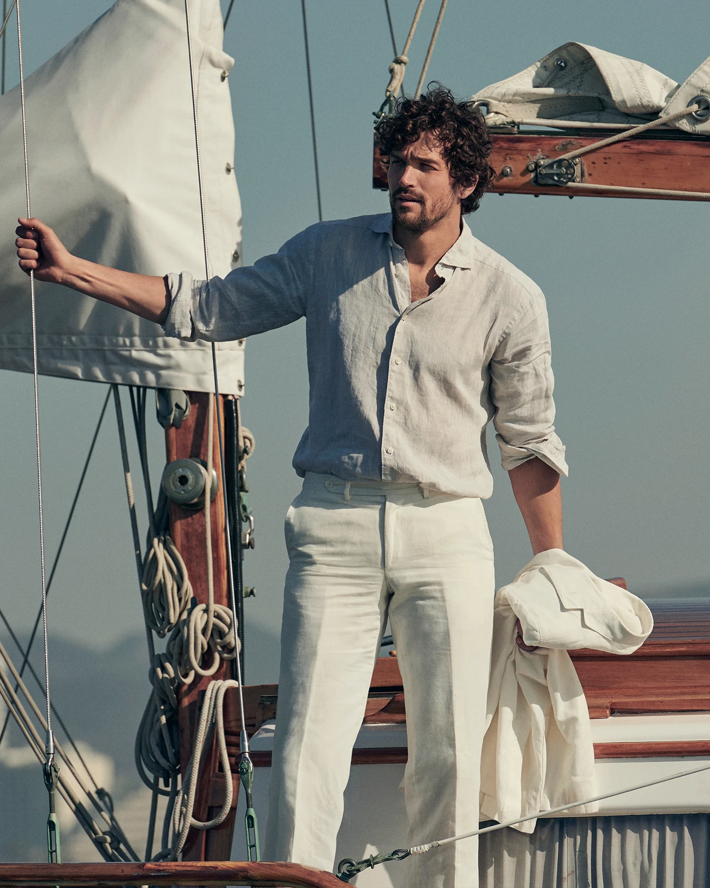 man on a boat wearing a beige linen shirt