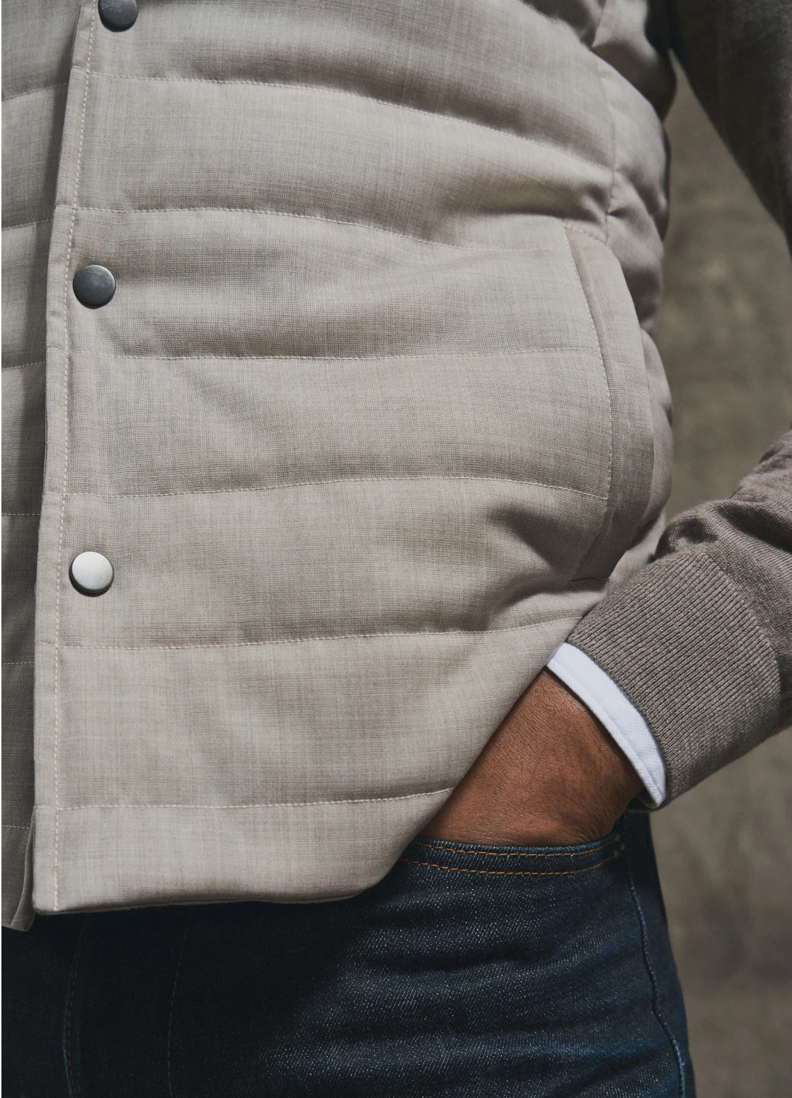 model in beige vest and layered look with shirt and knit sweater