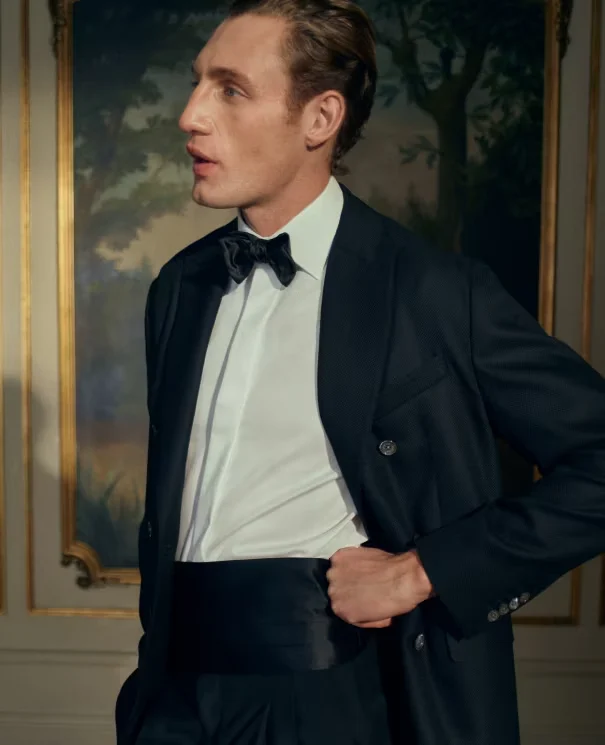 a model posing in a tuxedo in a old renaissance room