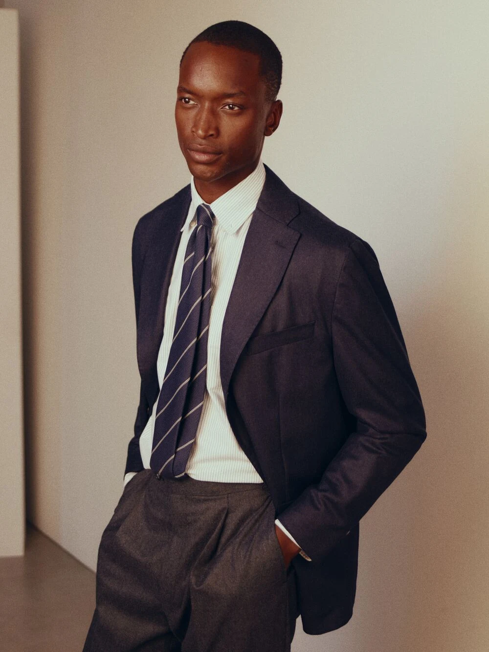 a man posing in a oxford shirt and soft jacket and tie