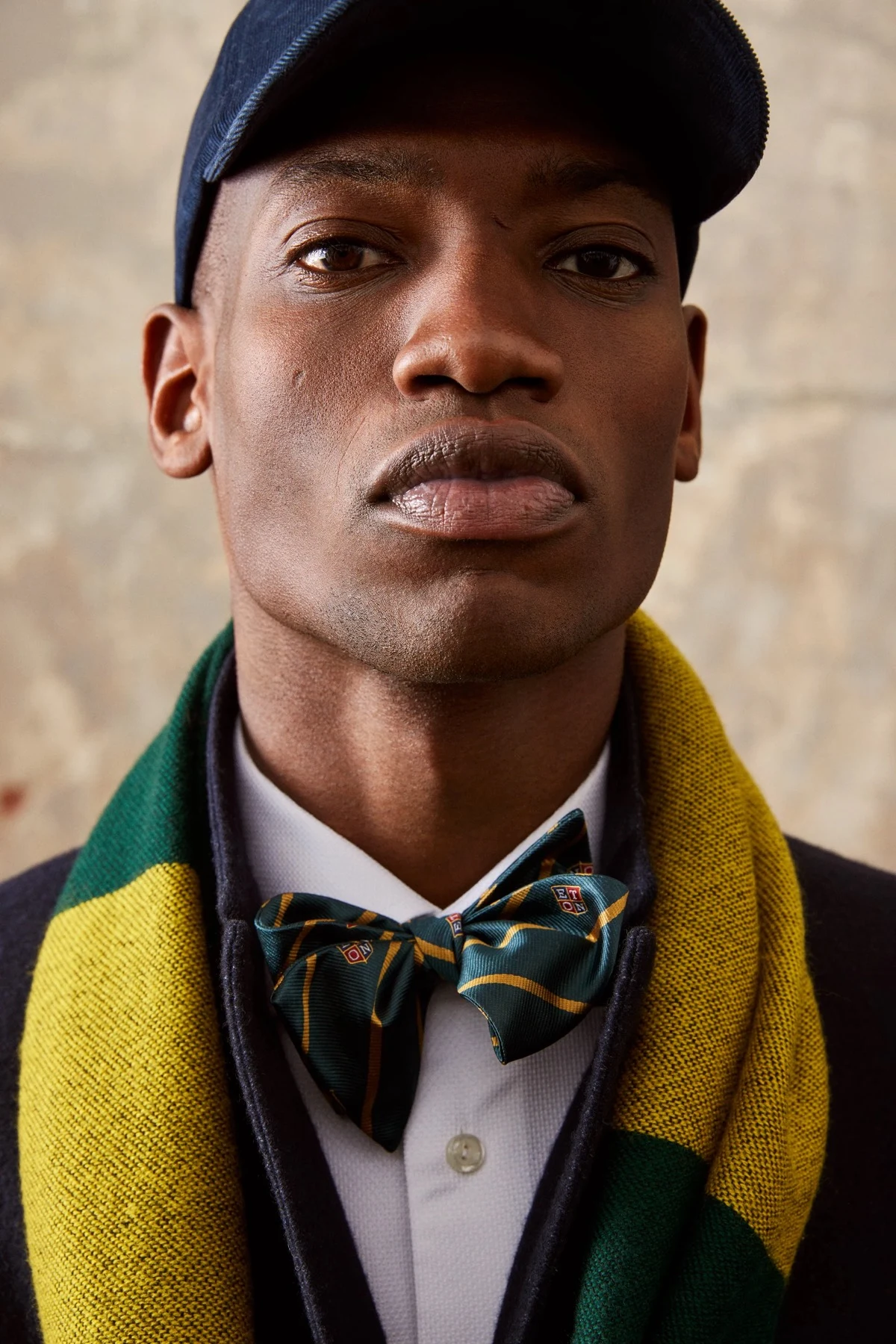 model wearing cap and green silk bow-tie