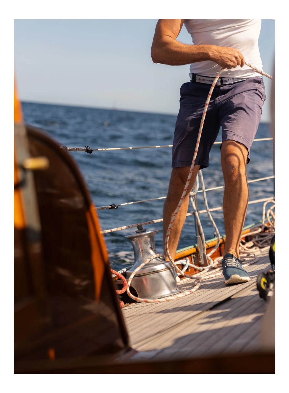 a guy pulling rope on a sailing boat