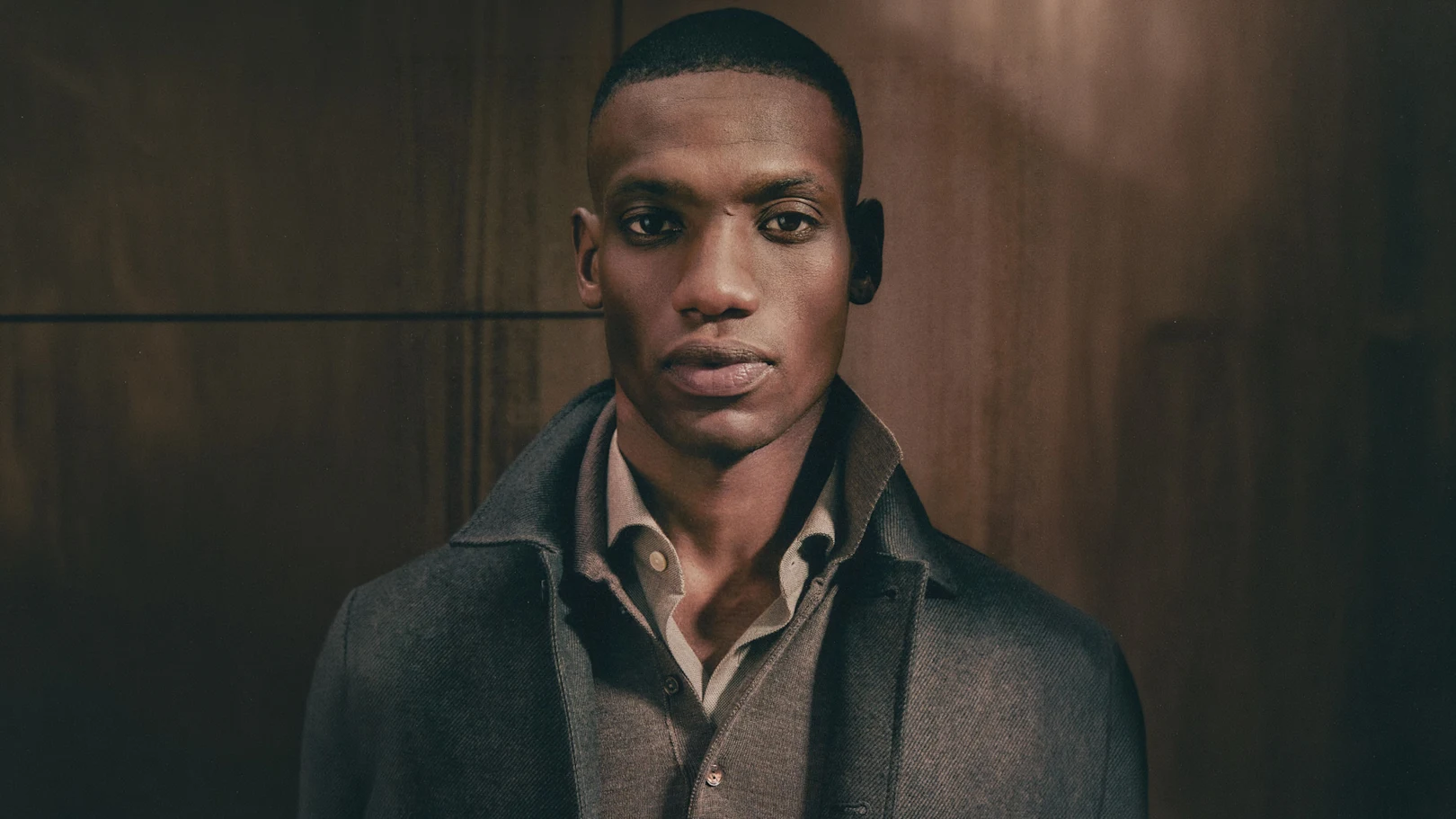 A man posing in a blue signature twill shirt and a navy striped grenadine tie