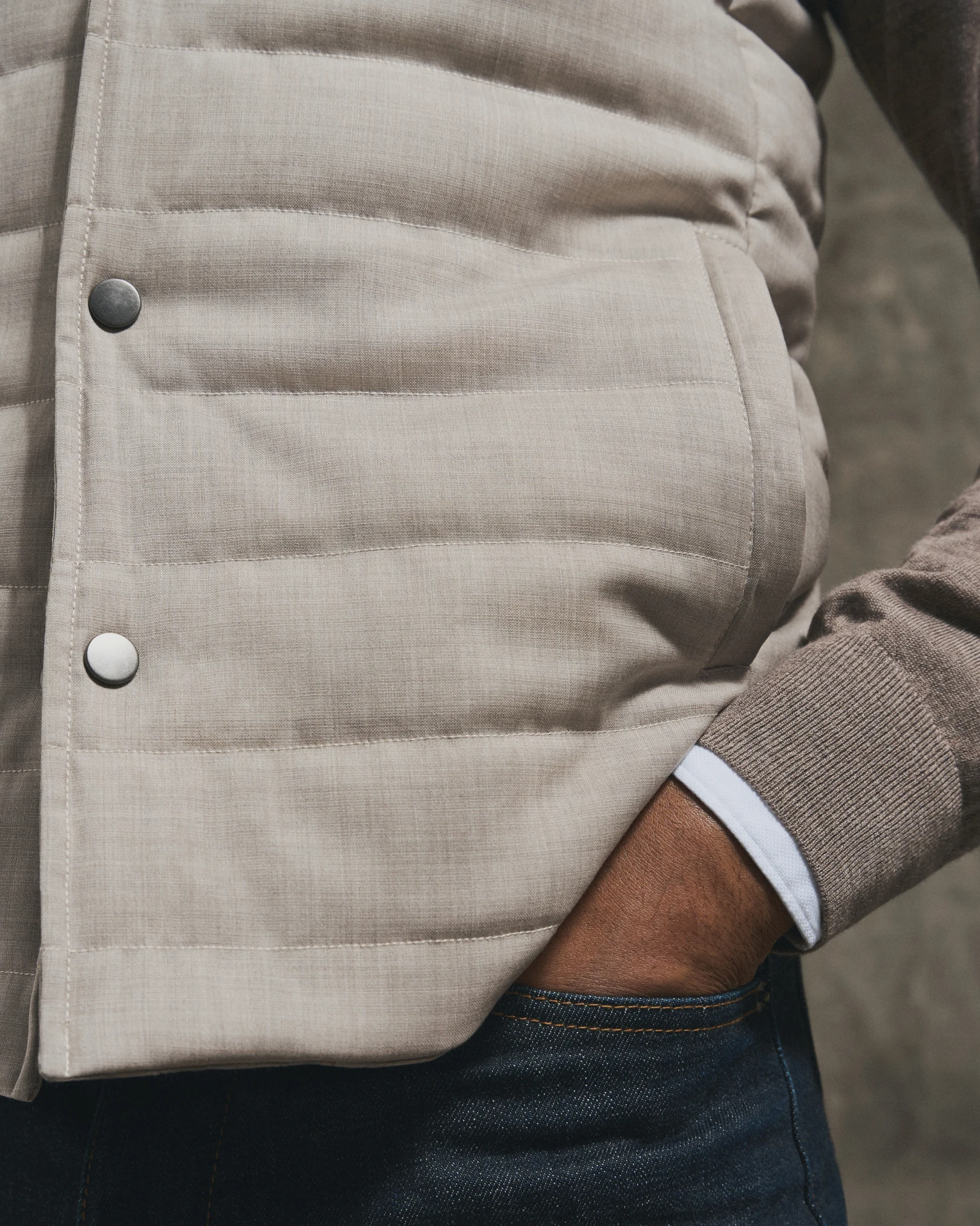 model in beige vest and layered look with shirt and knit sweater