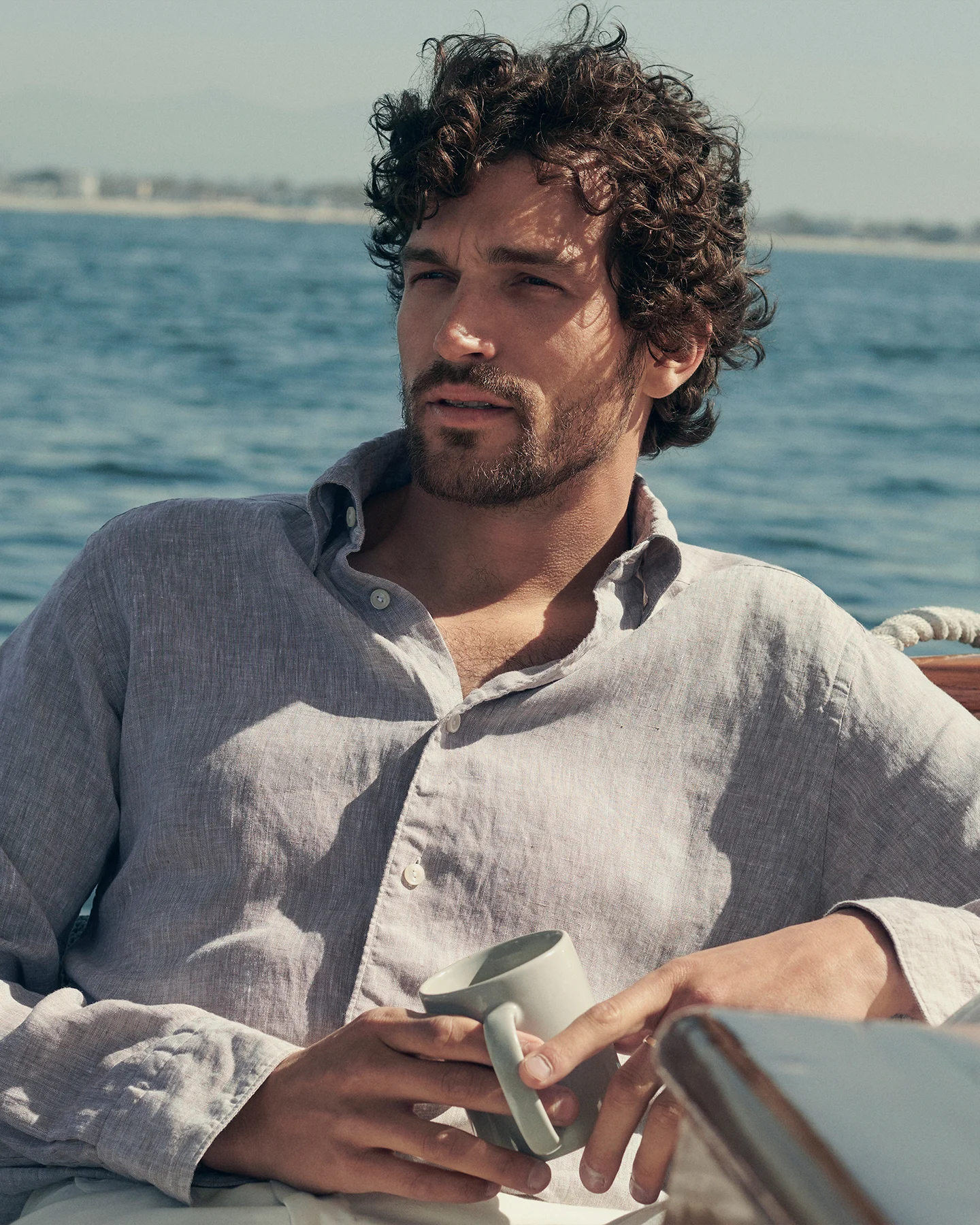 Man on a boat wearing a beige linen shirt