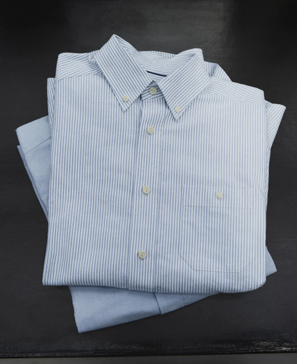two eton oxfords shirt folded on a table
