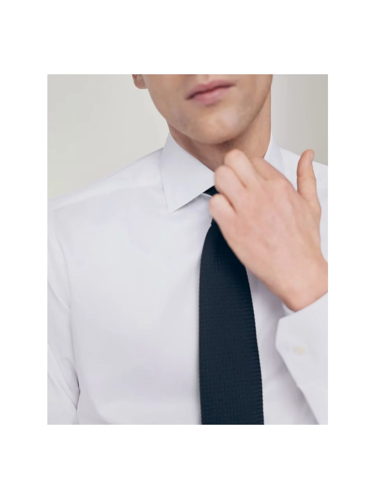 a man posing in a signature twill shirt with a tie