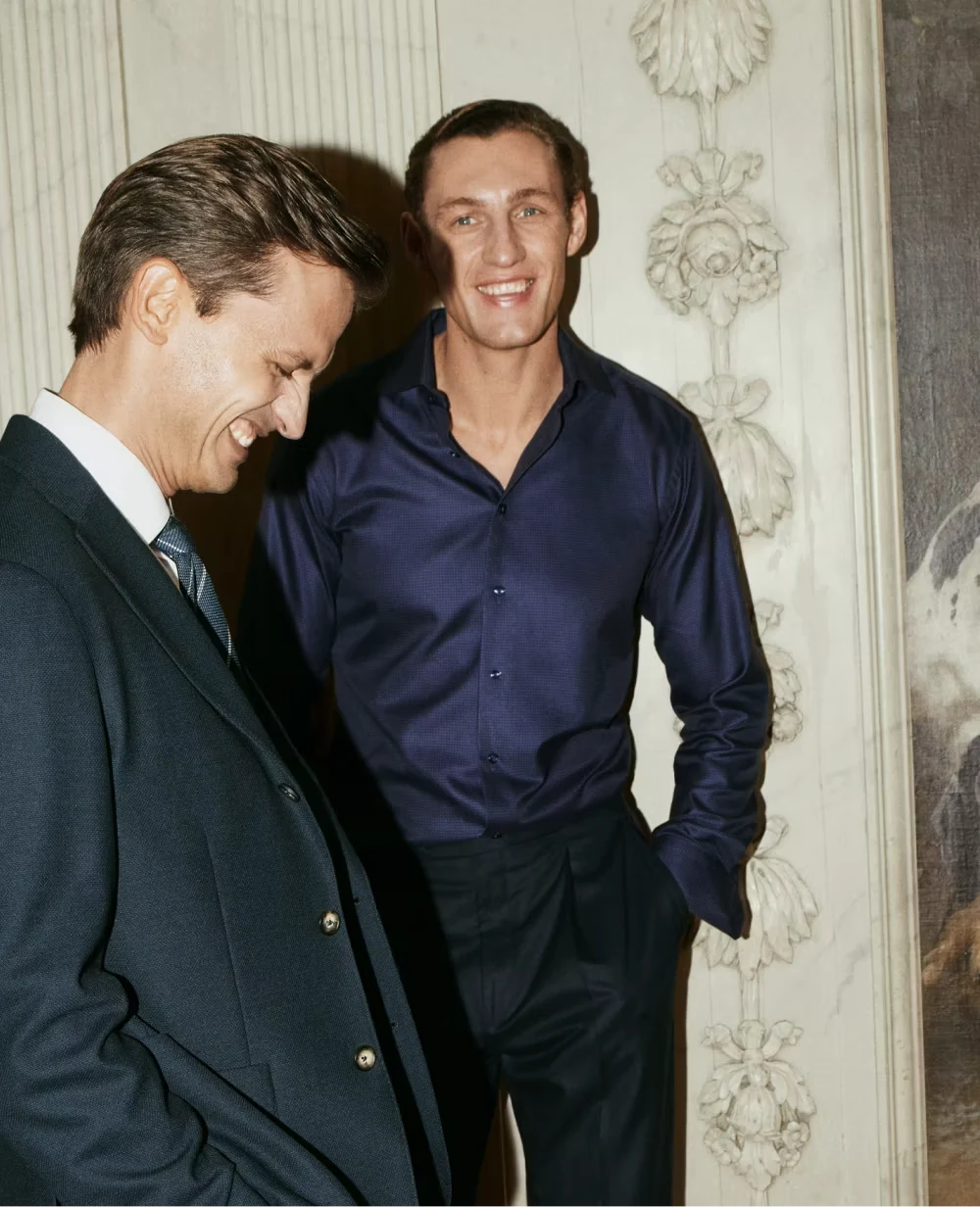 two men standing in an old room laughing