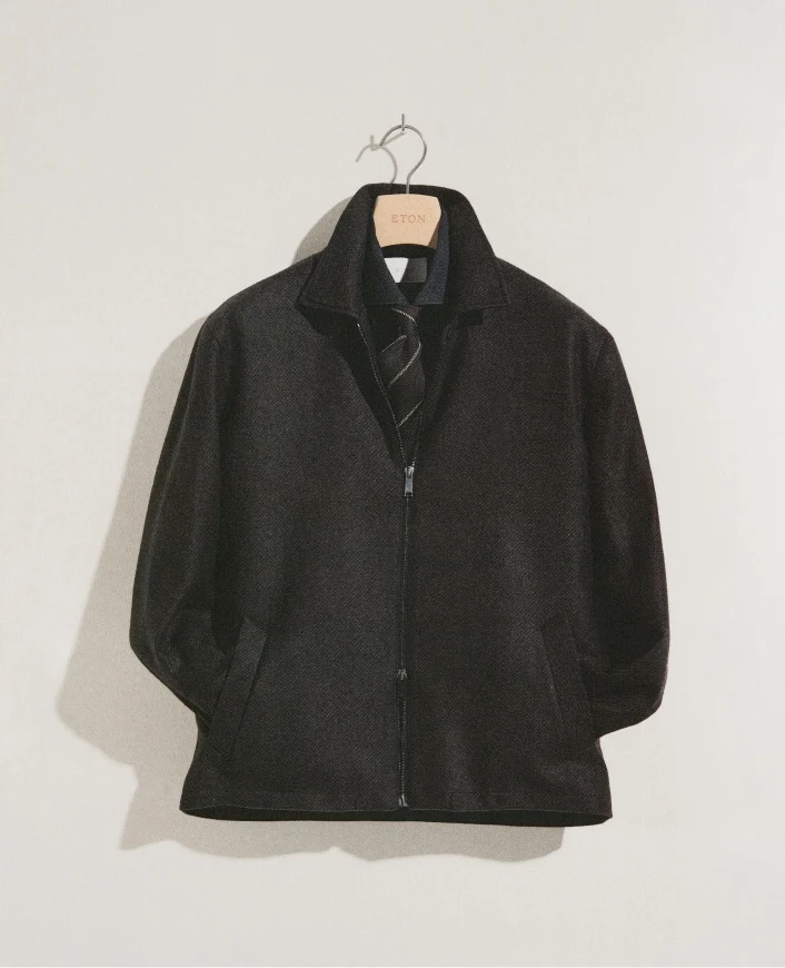 an outfit hanging on a hanger on an empty wall