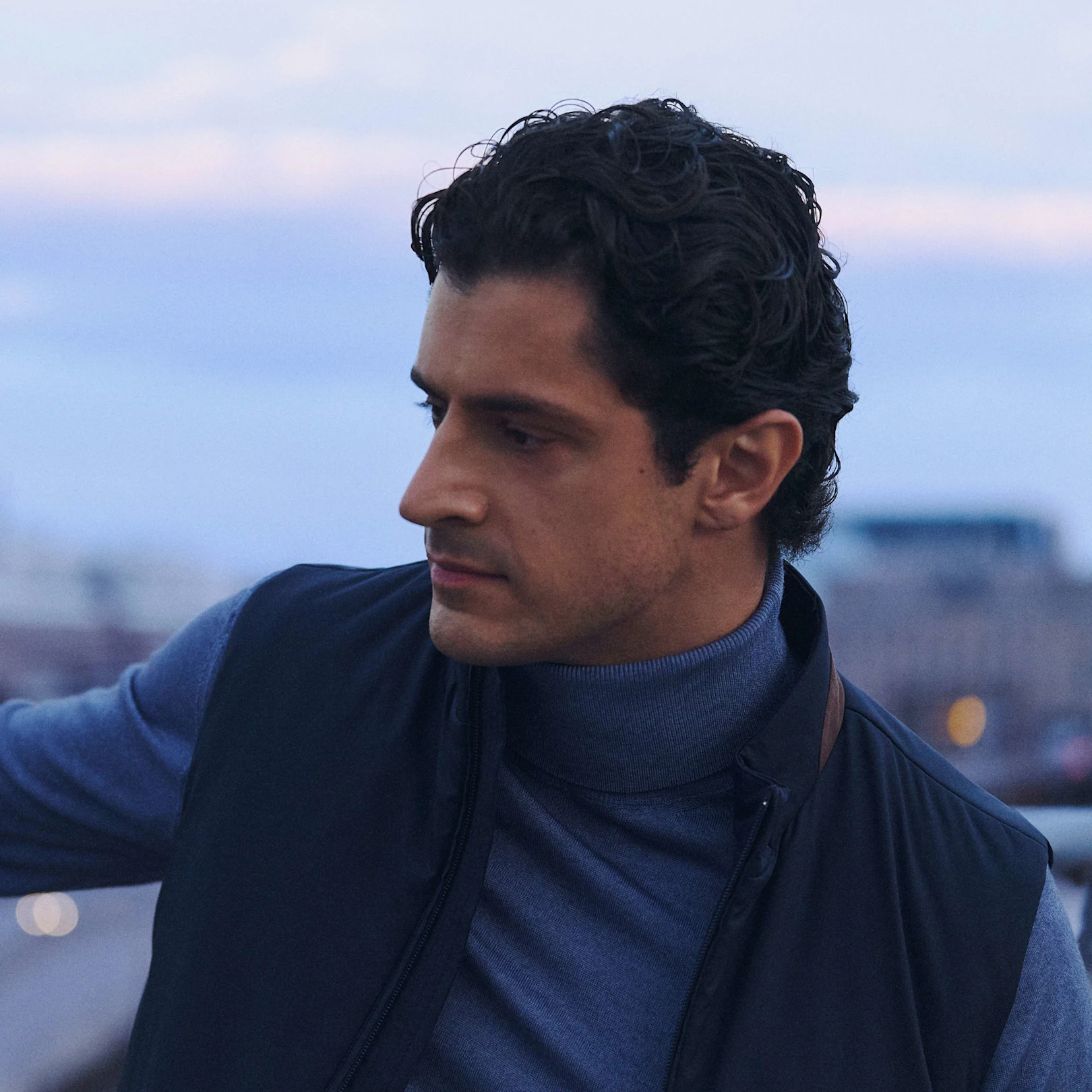 a man in a turtleneck and vest 