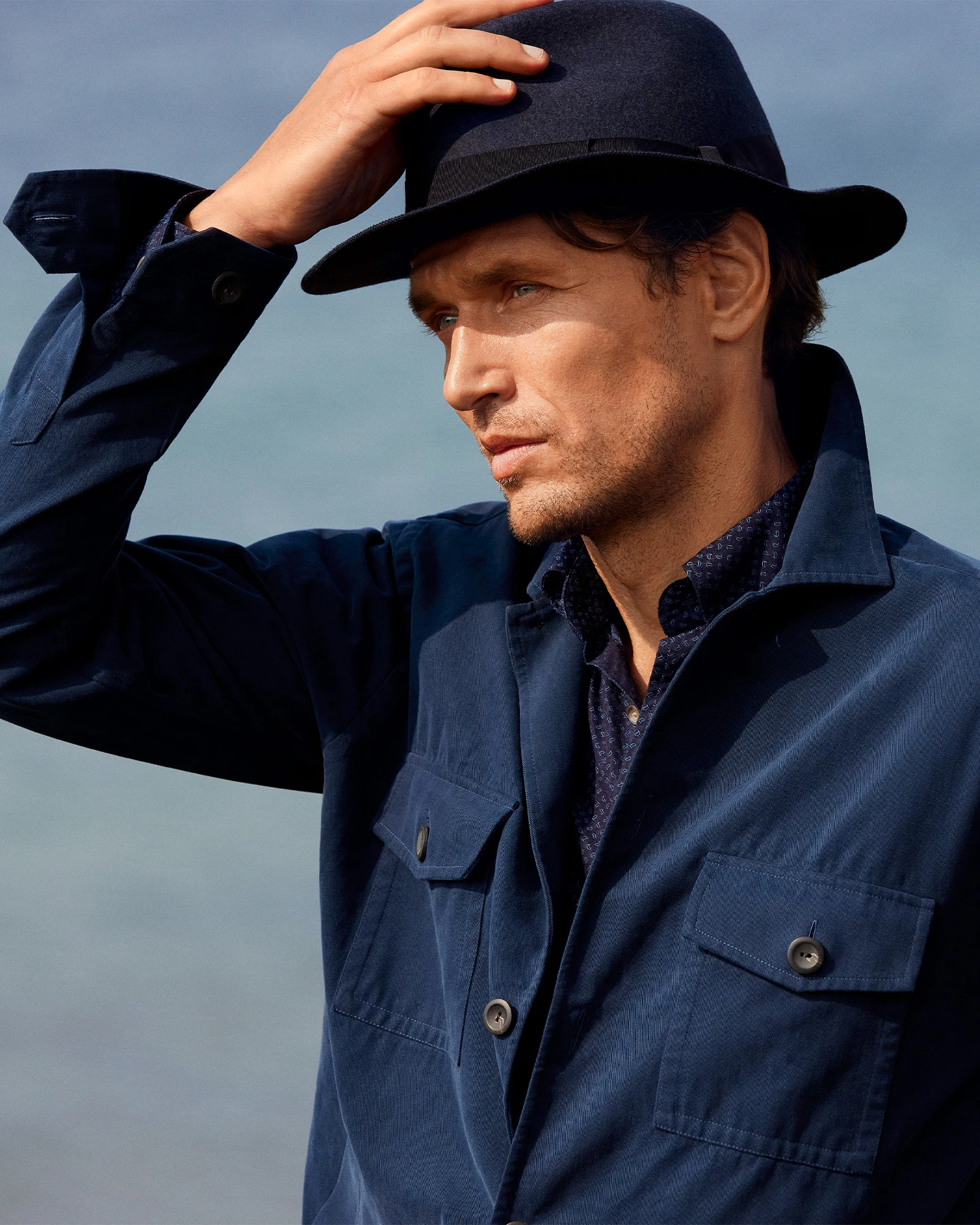 close up model image hat and navy overshirt