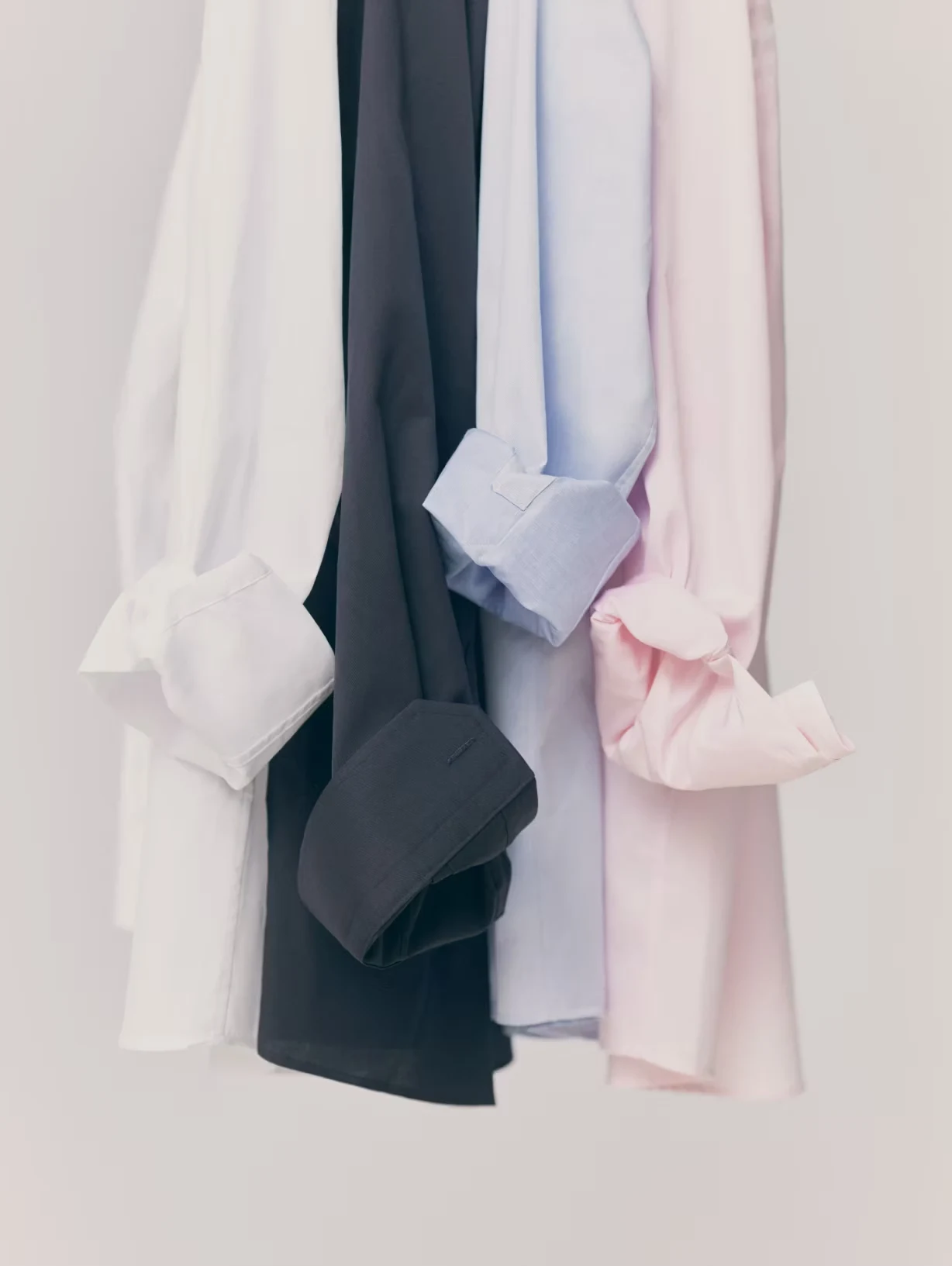 four different signature twill shirts hanging with rolled up sleeves
