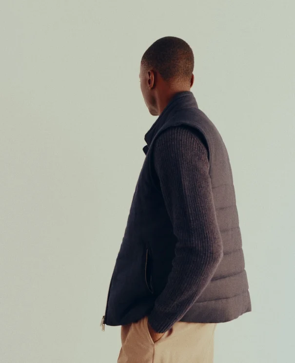 a model posing in a knitted cashmere sweater and a vest