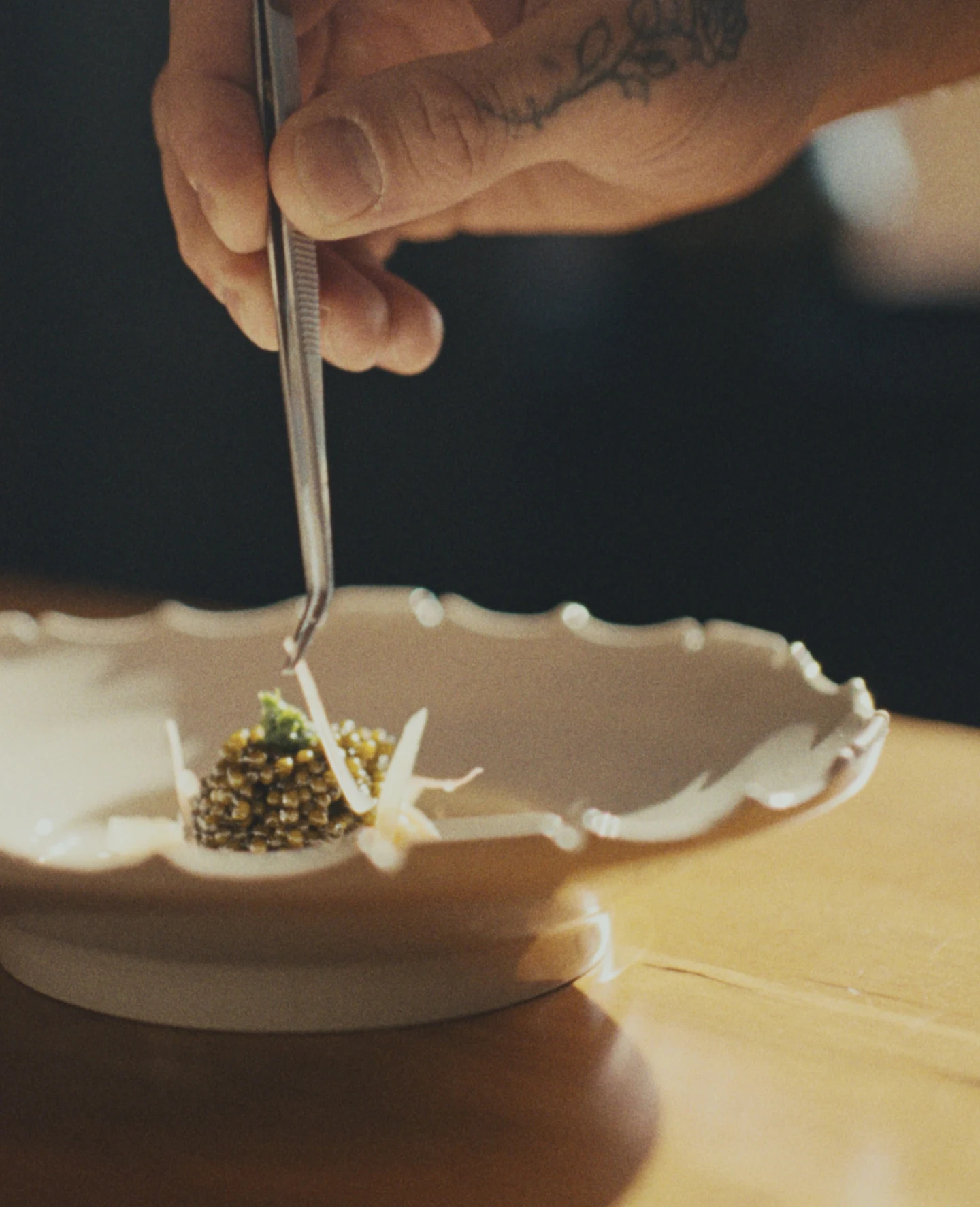 a michelin dish being finished with garnish by a proffesional chef