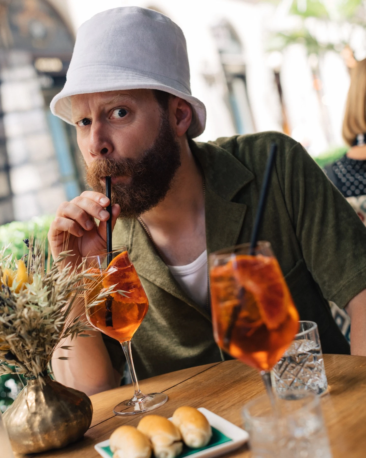 eton bucket hat and terry shirt on model drinking spritz