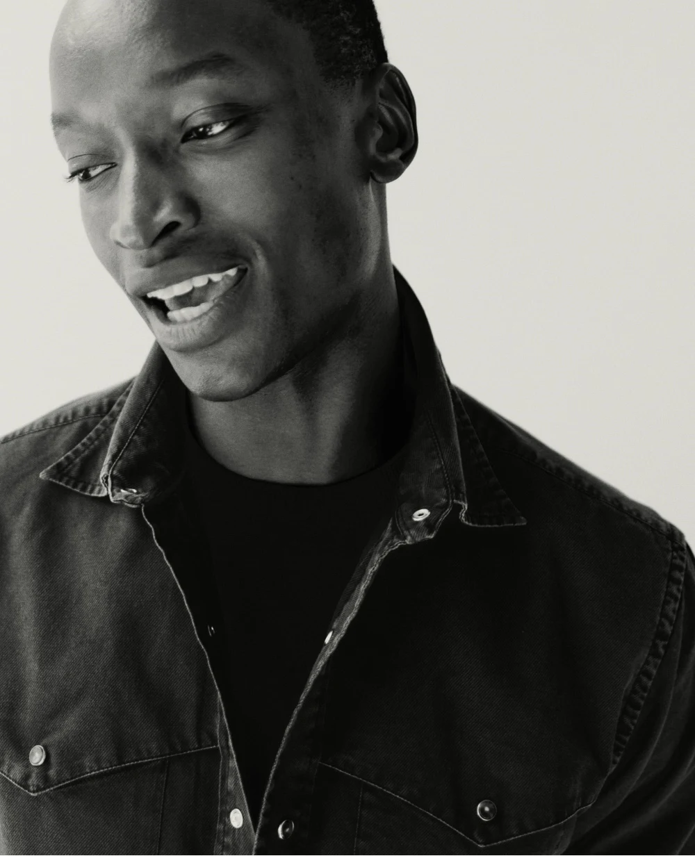 a black and white image of a model posing in a eton indigo western style shirt