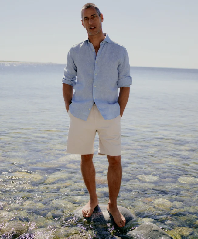 a man in a linen shirt by the water