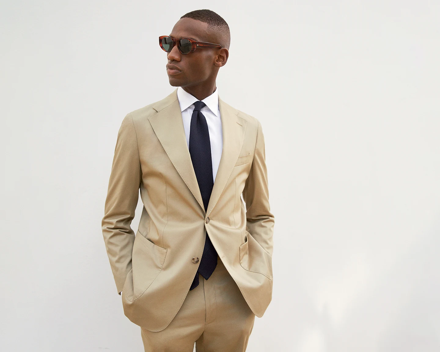 model in white shirt and beige suit