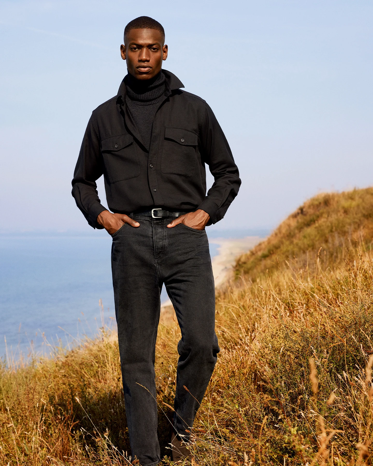 model in gray overshirt and dark jeans