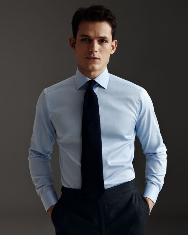 Man wearing a  blue shirt and a navy tie